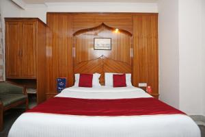 1 dormitorio con 1 cama grande y cabecero de madera en OYO Hotel Gold Palace, en Nueva Delhi