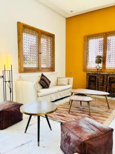 Villa Africa في الصويرة: غرفة معيشة مع أريكة وطاولتين