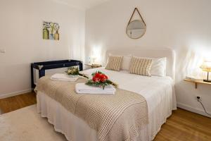 a bedroom with a large white bed with flowers on it at Hydrangea House in Água de Pau