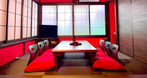 TRAVELERZ YOKOHAMA Demon Slayer House في Kikuna: قاعة اجتماعات مع طاولة وكراسي وتلفزيون