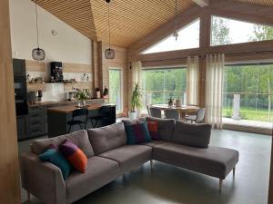 a living room with a couch and a kitchen at Villa Kiiski in Teijo
