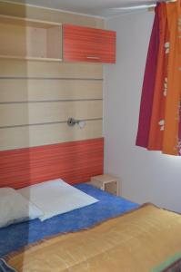 - une chambre dotée d'un lit avec un mur rouge et blanc dans l'établissement camping Le moulin, à Patornay