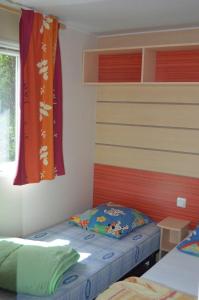 a bedroom with two beds and a window and a bedvisor at camping Le moulin in Patornay