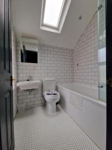 a bathroom with a toilet and a sink and a tub at Lovely 3 bedroom Whitley Bay Townhouse. in Whitley Bay
