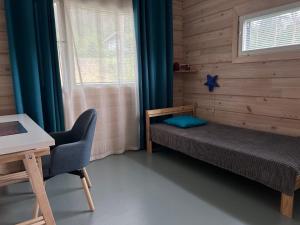 een slaapkamer met een bed, een bureau en een raam bij Villa Kiiski in Teijo
