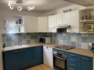 una cucina con armadi blu e bianchi e un lavandino di F3 hyper centre vieille ville coeur historique d'Ajaccio ad Ajaccio