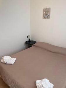 una camera da letto con un grande letto con due asciugamani bianchi di Appartamenti sul mare da Antonino a Mattinata