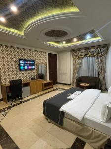 Hotel 5092 في أبوجا: غرفة نوم بسرير ومكتب وتلفزيون