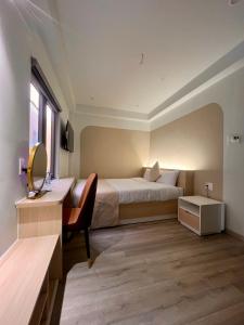 una camera da letto con un letto, una scrivania e uno specchio di Hoang Thang 1 Hotel Da Lat City a Da Lat Altre 23 foto