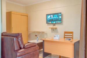 uma sala de estar com uma cadeira de couro e uma secretária em Mountain View Hotel & Apartment em Kigali