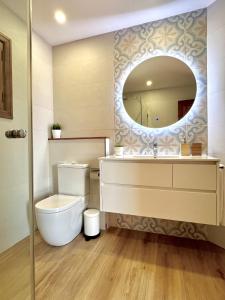 ein Badezimmer mit Toilette und Spiegel in der Unterkunft Villa Natural Barcarés in Alcúdia