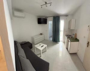 ein Wohnzimmer mit Sofa und Tisch in der Unterkunft Rooms with shared kitchen "Milica" in Drvenik