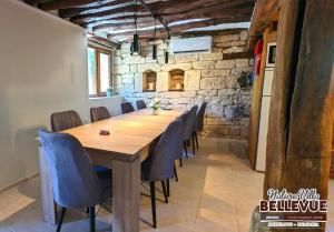 Un comedor con mesa y sillas de madera. en Arode Nature Villa Bellevue, en Katselovo