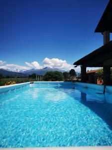 uma piscina com água azul e montanhas ao fundo em Orto del pettirosso em Front