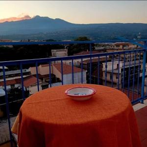 uma mesa com um prato no topo de uma varanda em Casa Donna Rosaria tra Etna e Taormina em Riposto