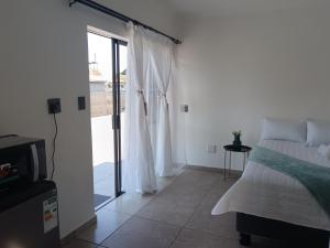 a bedroom with a bed and a sliding glass door at Peacefull Haven in Rustenburg