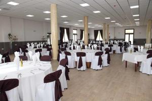 a banquet hall with white tables and chairs at Hotel Lorenzo in El Contador