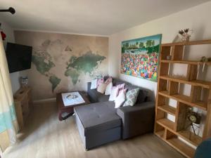 a living room with a couch and a map on the wall at Appartamento Baja Sardinia in Baja Sardinia