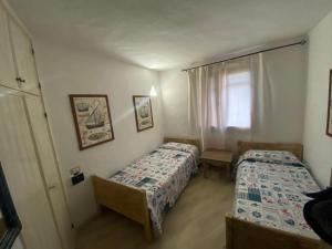 a bedroom with two beds and a window at Appartamento Baja Sardinia in Baja Sardinia