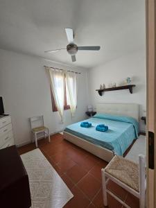 Schlafzimmer mit einem Bett und einem Deckenventilator in der Unterkunft Casa La Pelosa in Stintino