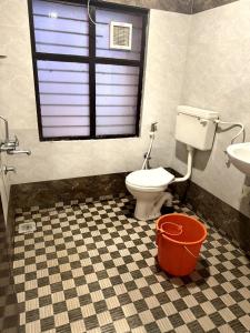 un bagno con un water, un lavandino e una finestra di Jaya Tourist Home a Varkala Altre 7 foto