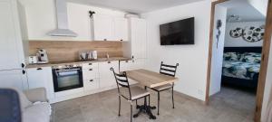 a kitchen with a table and chairs and a bed at LES BOIS DE ZOLA entre Provence et Luberon in Saint-Estève-Janson