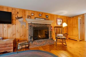 a living room with a fireplace and a chair at James Place Inn Bed and Breakfast in Freeport