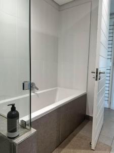 a bathroom with a shower with a bath tub at Two Bedroom at Pebble Beach in Umhlanga