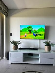 a living room with a flat screen tv on a wall at Two Bedroom at Pebble Beach in Umhlanga