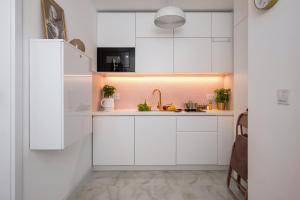Una cocina con gabinetes blancos y un fregadero. en Stunning 2-BR Apartament Palace in the window, air-conditioning 500m to Central Station, en Varsovia 24 fotos más