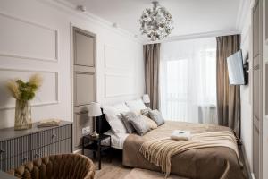 Un dormitorio con una cama, una silla y una lámpara de araña. en Stunning 2-BR Apartament Palace in the window, air-conditioning 500m to Central Station, en Varsovia