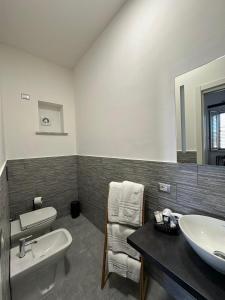La salle de bains est pourvue d'un lavabo, de toilettes et d'un miroir. dans l'établissement Grenada Home, à Praia a Mare
