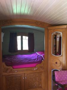 małe łóżko w pokoju z lustrem w obiekcie Bungalow de 2 chambres avec piscine partagee jardin et wifi a Saint Pardoux w mieście Saint-Pardoux