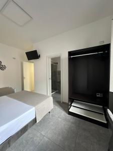 - une chambre avec une grande télévision à écran plat et un lit dans l'établissement Grenada Home, à Praia a Mare