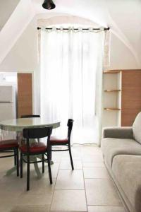un soggiorno con tavolo, sedie e divano di Casa Bruni 104 a Putignano