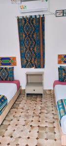 um quarto com 2 camas e piso em azulejo em SULTANA Beach Riad em Saïdia