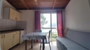 a small kitchen with a table and a window at Villa Franić in Saplunara
