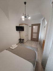 a bedroom with a bed and a flat screen tv at Garsoniera Vivere in Sibiu