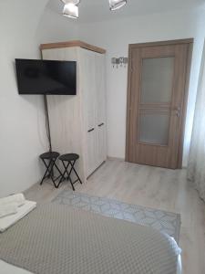 a bedroom with a bed and a tv and a door at Garsoniera Vivere in Sibiu