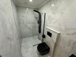 a bathroom with a shower with a black toilet at TUVA VİLLA Bungalov in Çamlıhemşin