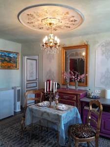 a dining room with a table and chairs and a chandelier at Appartement de Ville Médiévale in Vinça