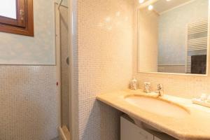 a bathroom with a sink and a mirror and a shower at Casa Angelo Olbia mare - Gulf of Olbia sea view- in Olbia +14 photos