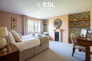 a bedroom with a bed and a desk and a mirror at Large Country Farmhouse with Hot Tub and Shropshire Hills View in Minsterley