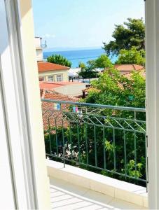 a balcony with a view of the ocean at Jasmin Apartment Blue in Hanioti +3 photos