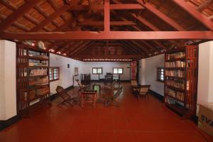 a room with a table and chairs and books at Vilayara Heritage Retreat -Kozhikode in Kunnamangalam