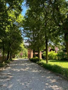 une route bordée d'arbres avec un bâtiment au loin dans l'établissement Portego mio, à Selvazzano Dentro