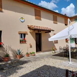 a house with a patio and an umbrella at Bed&Breakfast Pianeta Benessere in Pistoia
