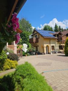 a house with a blue roof with a courtyard at Wieczorek Pokoje Gościnne Całoroczne jacuzzi ogrodowe in Szczyrk