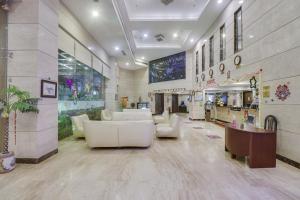 un vestíbulo con muebles blancos en un edificio en Palette - Hotel chennai le palace en Chennai