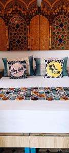 a bed with pillows and a wooden head board at SULTANA Beach Riad in Saidia 